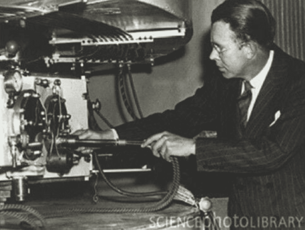 Ernest Lawrence adjusting the ion source of a cyclotron